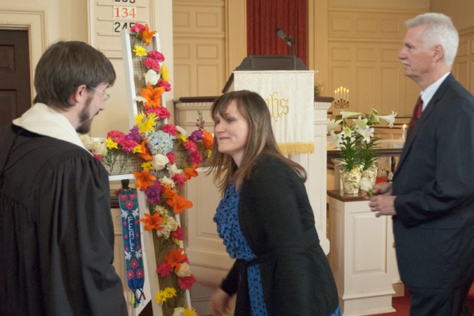 Everyone is invited to take a flower as they enter the sanctuary and, early in the service, one by one those flowers are added to the cross.